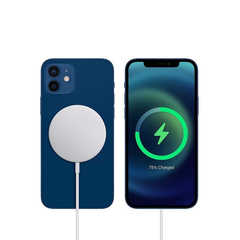 Chargeur Apple Magsafe rond argenté avec câble blanc, aimanté au dos d’un iPhone bleu; charge sans fil affichée à 75 pourcent sur l’écran
