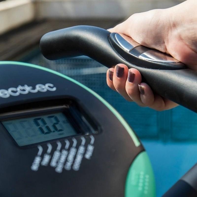 Bicicleta de exercício dobrável X-Bike com visor LCD e guidão ergonômico; mão ajustando sensor de pulso; detalhes em preto e verde