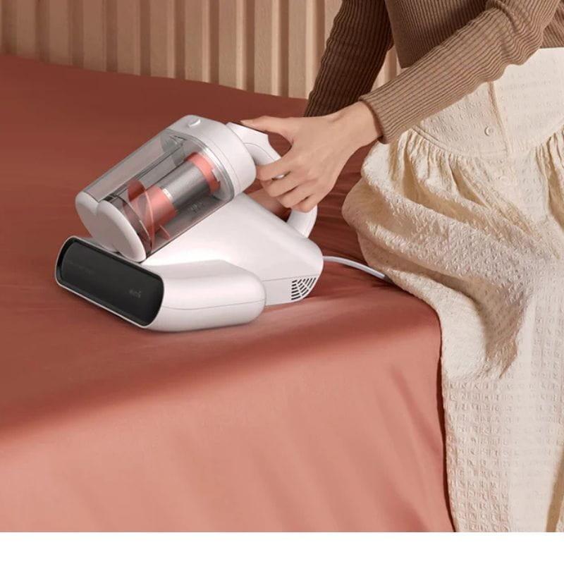 DEM-CM980W - Image d'un aspirateur à main sur un lit