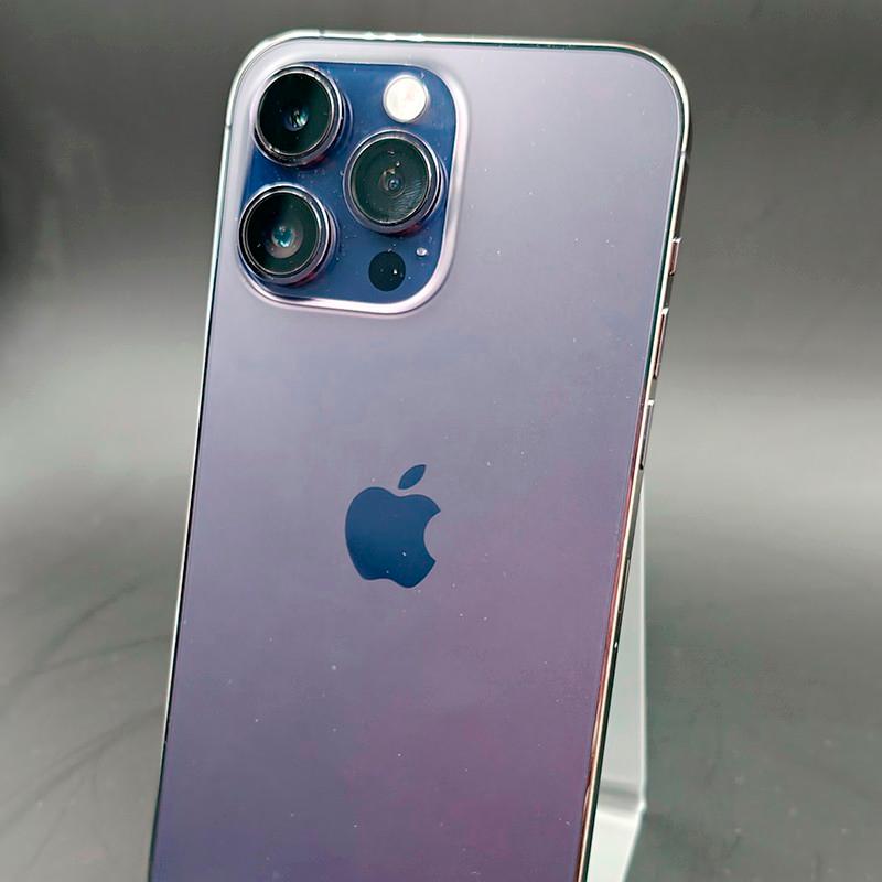 iPhone 14 Pro Max morado oscuro, acabado brillante, triple cámara trasera con lentes grandes, bordes metálicos pulidos; aspecto renovado en excelente estado.