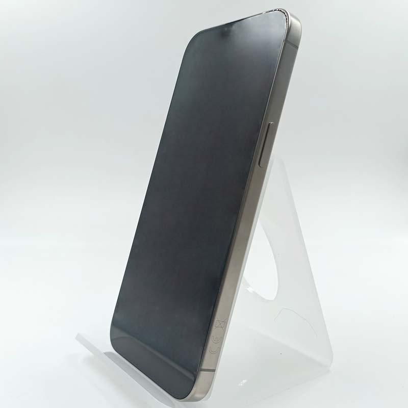 iPhone 15 Pro Max 5G 256GB, color titanio natural, acabado mate. Pantalla grande sin notch visible, bordes rectos y botón lateral. Estado premium renovado.