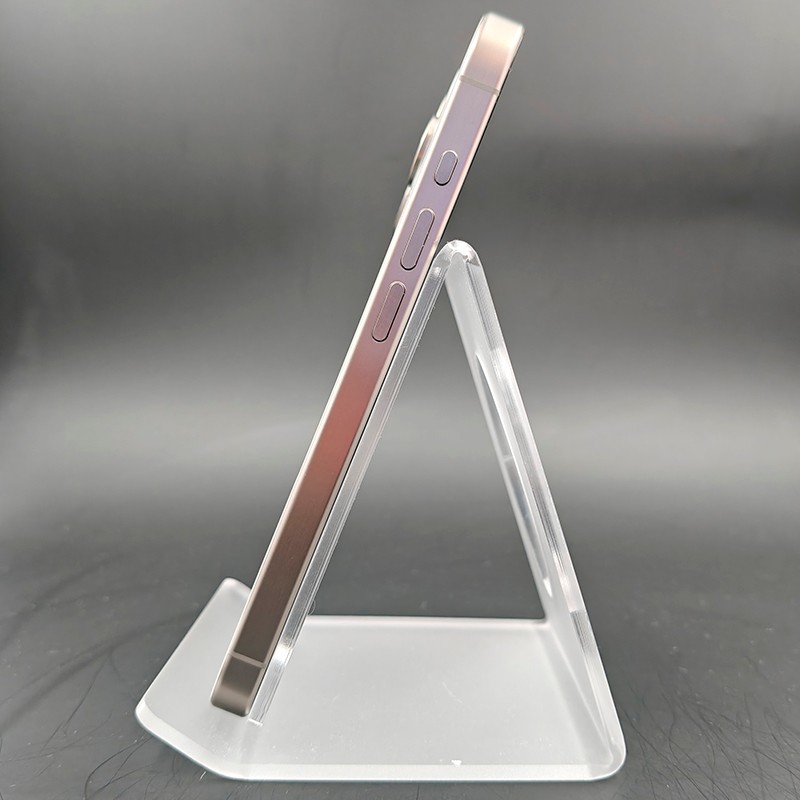 Profil latéral de l’iPhone 15 Pro 5G 256Go Titane Naturel Renewed, cadre en titane brossé, boutons affleurants, bords plats, posé sur support transparent.