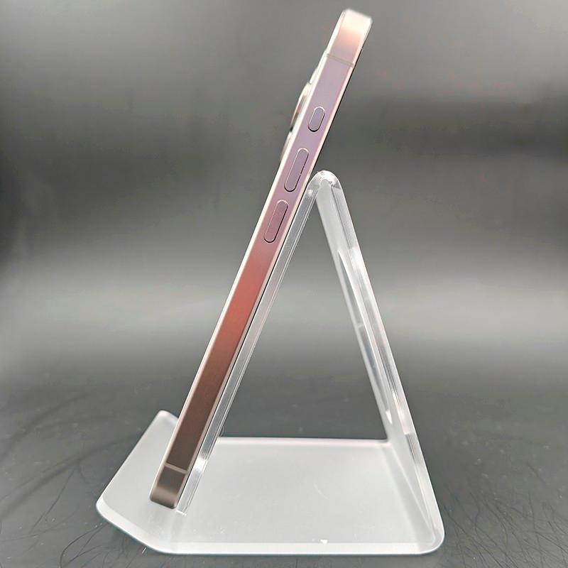 Profil latéral de l’iPhone 15 Pro 5G 256Go Titane Naturel Renewed, cadre en titane brossé, boutons affleurants, bords plats, posé sur support transparent.