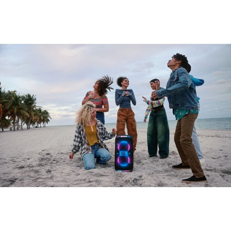 Chicos bailando con el Altavoz Portátil JBL Partybox 120 Club en la playa