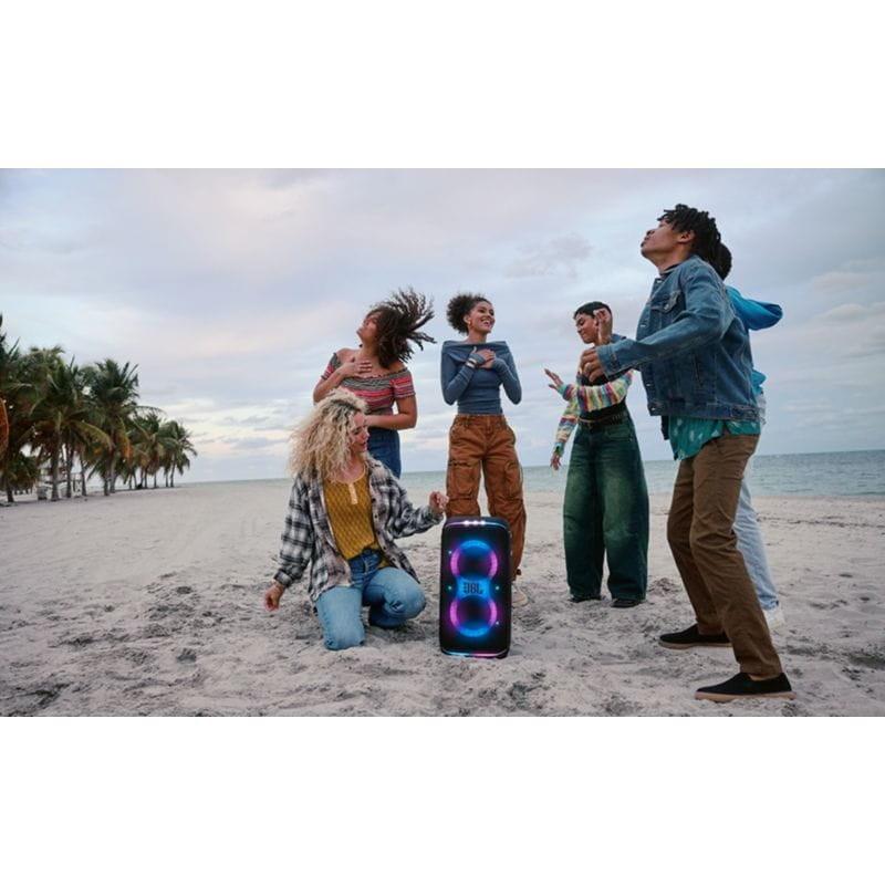 Chicos bailando con el Altavoz Portátil JBL Partybox 120 Club en la playa