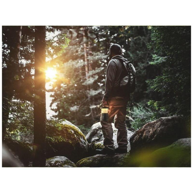 Jeune homme tenant le Haut-parleur portable Mifa Wild Camping Bluetooth Lanterne LED Noir