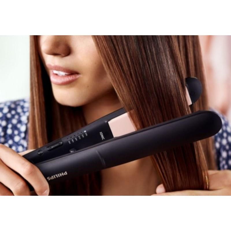 Femme lissant ses cheveux avec le Lisseur à cheveux Philips Essential StraightCare BHS378/00 Noir/Rose