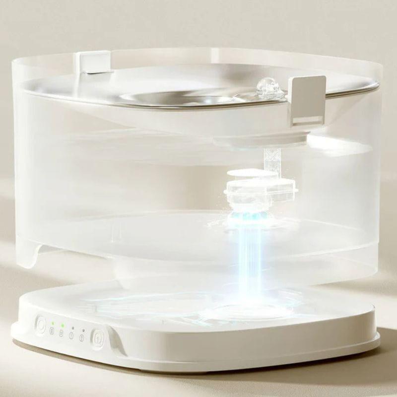 Elfin Pet Fountain D1 Pro Bebedero Automático sin bomba con depósito transparente, base blanca con controles LED y sistema de filtrado visible en el centro
