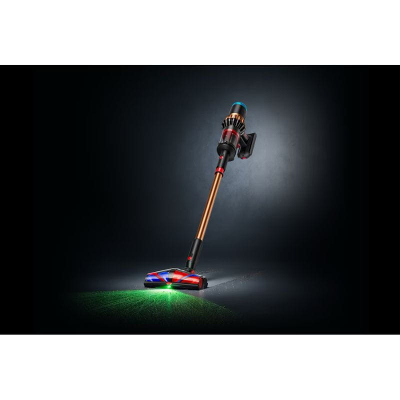 Dyson V16 Piston Animal sin cable: tubo cobre, cuerpo negro/rojo, cabezal motorizado con luces LED y haz verde que ilumina el polvo en el suelo.
