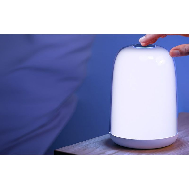Lámpara inteligente LED blanca cilíndrica con base gris, luz uniforme regulable; control táctil superior, diseño minimalista para mesita de noche.