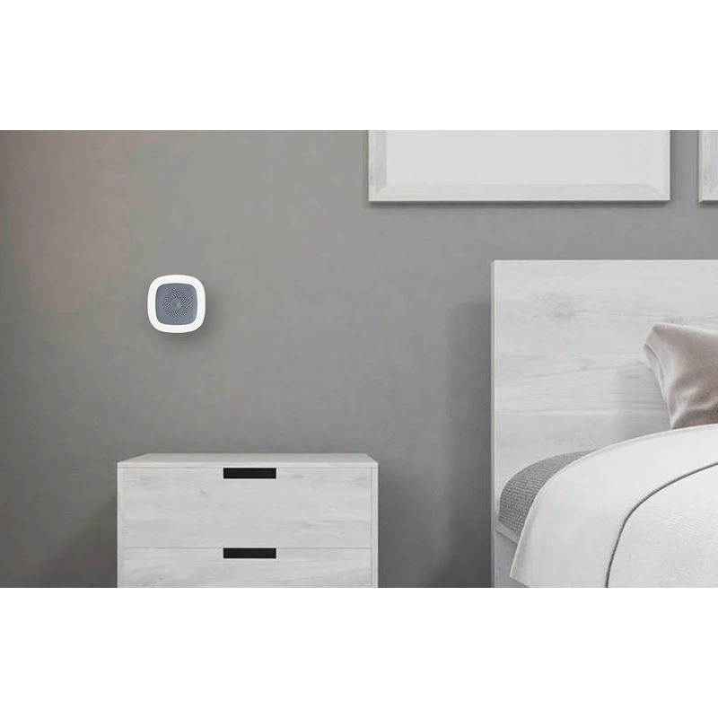 Heiman HS1HT Tuya Zigbee Sensor de temperatura y humedad blanco, compacto y cuadrado, con rejilla central gris montado en pared junto a mueble claro