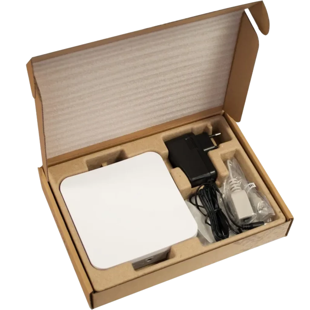 Mikrotik SXTsq Lite5 en caja: unidad blanca cuadrada compacta, fuente de alimentación, inyector PoE y cables organizados en inserto de cartón