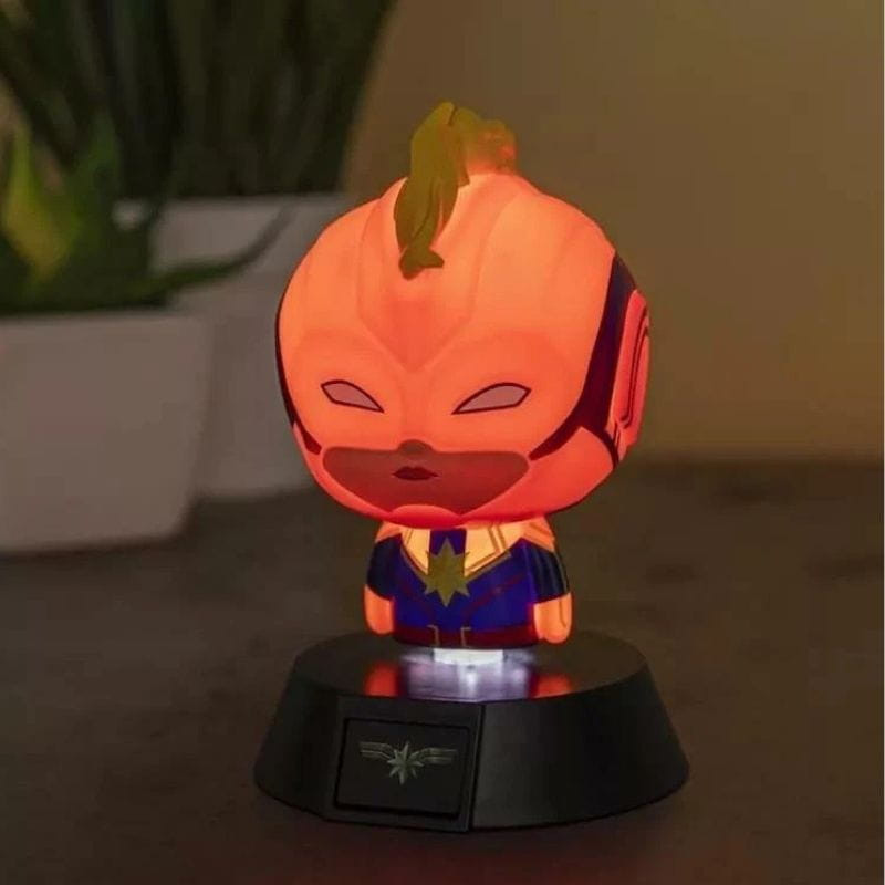 Lámpara Paladone Icon Captain Marvel: mini figura chibi iluminada en tonos cálidos, traje azul con estrella dorada, base negra con emblema brillante.