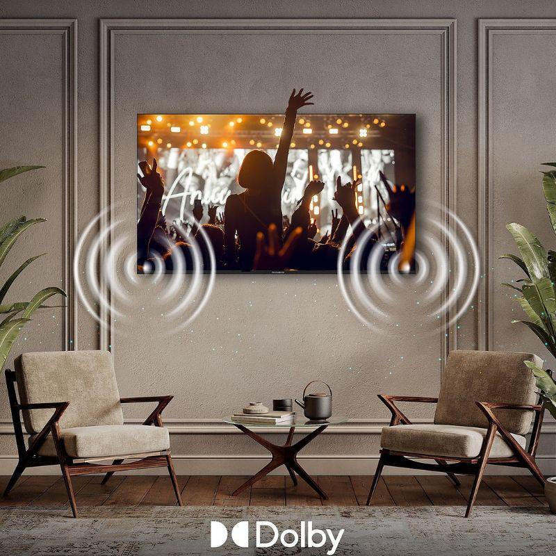 THOMSON 40FQG3S15 40" Smart TV, pantalla plana montada en pared, marco delgado, imagen vívida y sonido Dolby con ondas acústicas destacadas.