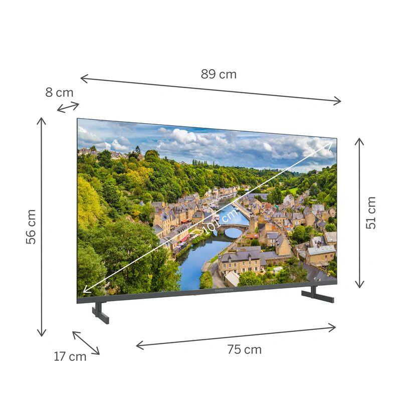 THOMSON 40FQG3S15 40" Smart TV con biseles finos, peana doble, 89×56×17 cm. Pantalla 102 cm diagonal mostrando paisaje urbano nítido y colorido.
