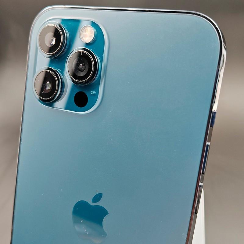 Câmera traseira tripla do iPhone 12 Pro Max azul pacífico, lentes grandes com aro metálico, flash e sensor LiDAR em acabamento brilhante premium.