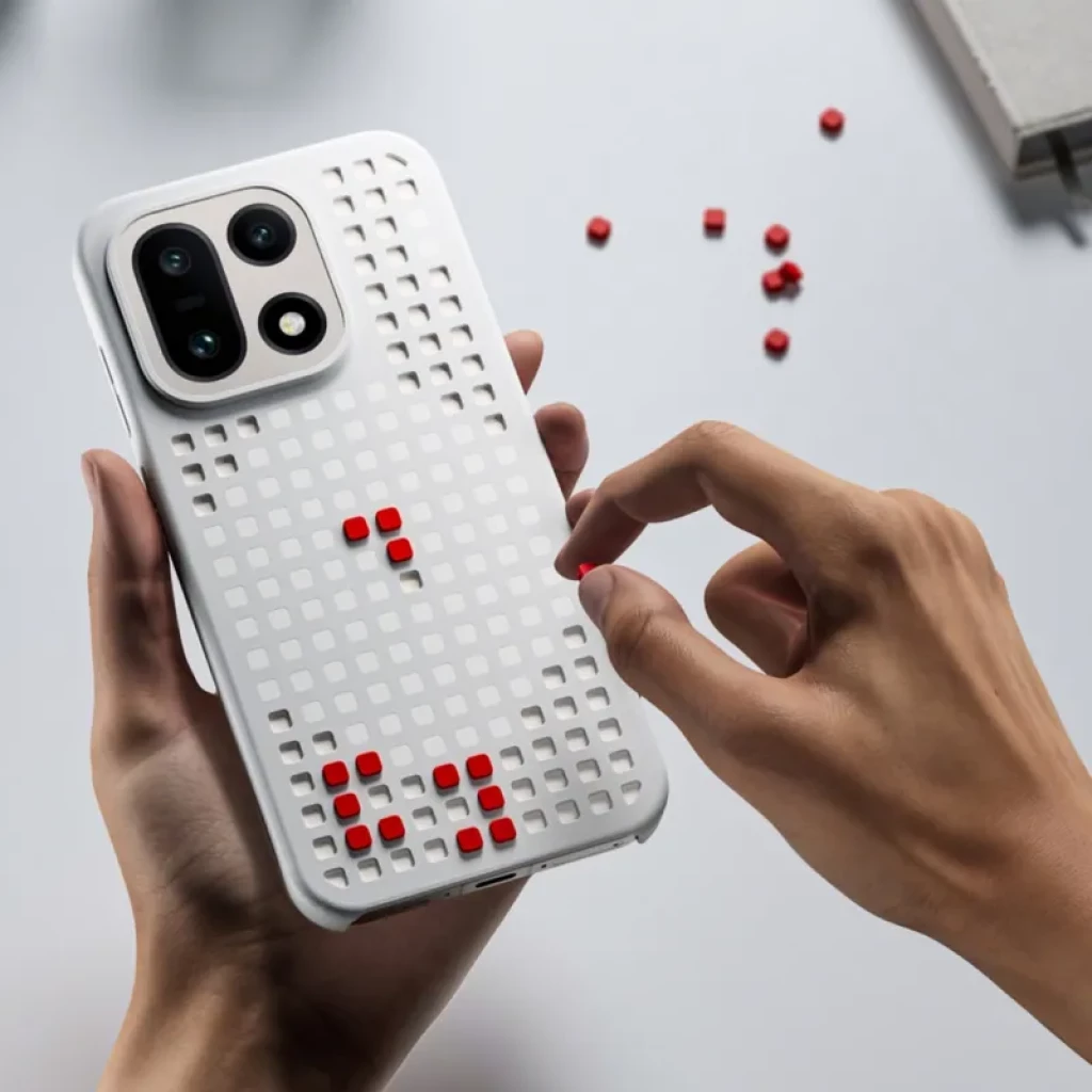 Capa magnética OnePlus 15 Hole-pattern cinzento com grelha quadrada e pequenos pinos vermelhos destacáveis, proteção robusta e design lúdico