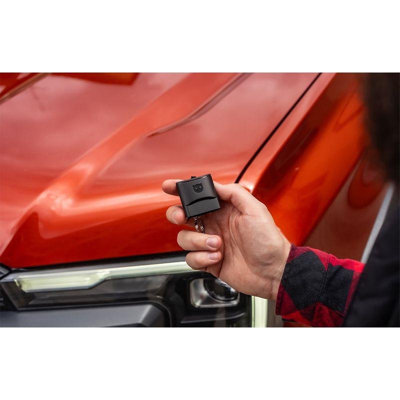 Scanner de diagnostic OBDeleven 3 Pro Pack : petit module OBD compact noir tenu en main, design discret, idéal pour prise OBD d’un véhicule moderne rouge.