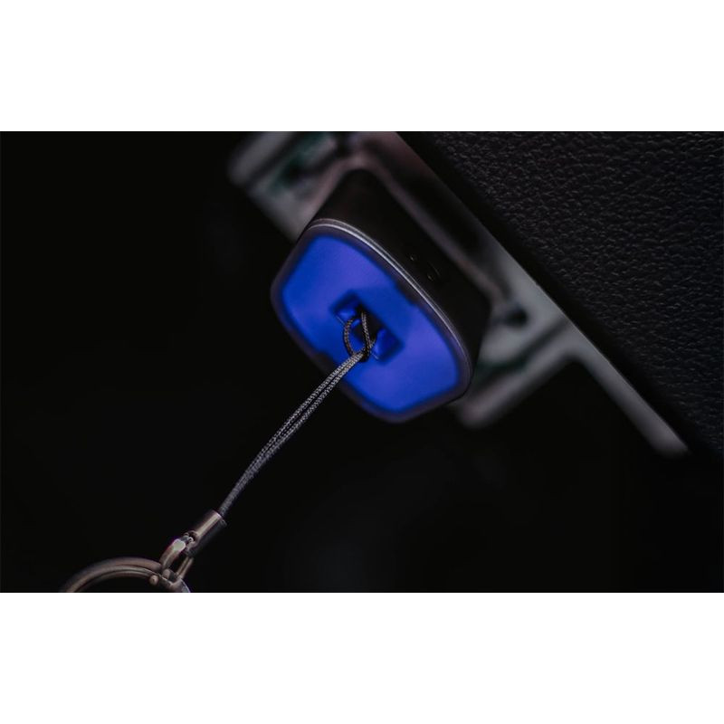 Dongle OBDeleven bleu branché au port OBD, compact avec anneau métallique; éclairage LED visible, finition mate, idéal pour diagnostic auto.