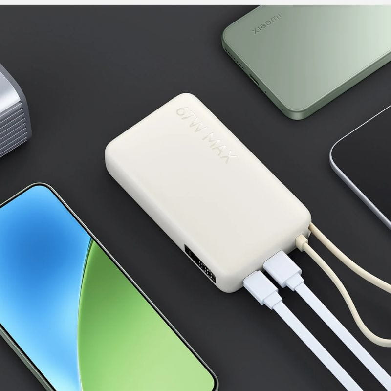 Batterie externe compacte bleu glacier 10000 mAh, charge rapide 67W, câble intégré, deux ports USB, design épuré posé parmi smartphones et accessoires