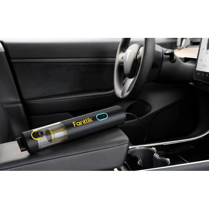 Fanttik V8 Apex aspirateur portable sans fil noir, corps cylindrique compact avec réservoir transparent et bouton turquoise, posé dans lhabitacle dune voiture
