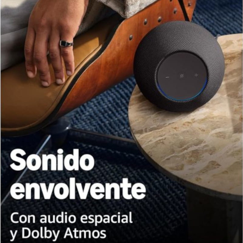 Amazon Echo Studio Grafito em tecido escuro, formato cilíndrico compacto, painel superior com botões táteis e anel de luz azul indicando atividade