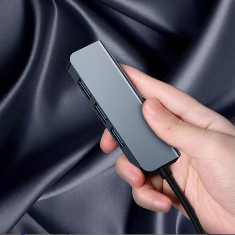 Hub USB BYL-2013U 4 en 1 gris, compacto en aluminio, con 3 puertos USB-A visibles azules tipo USB 3.0 y cable integrado negro, diseño angular elegante