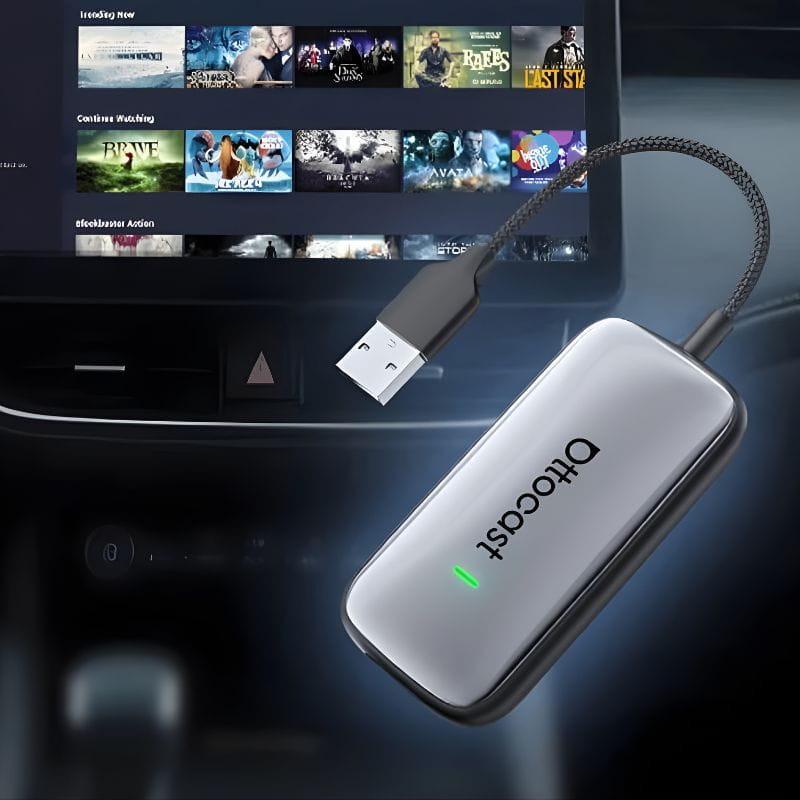 Ottocast Play2Video Ultra adaptador compacto gris con luz LED verde y cable USB trenzado, conectado al sistema del coche para CarPlay y Android Auto