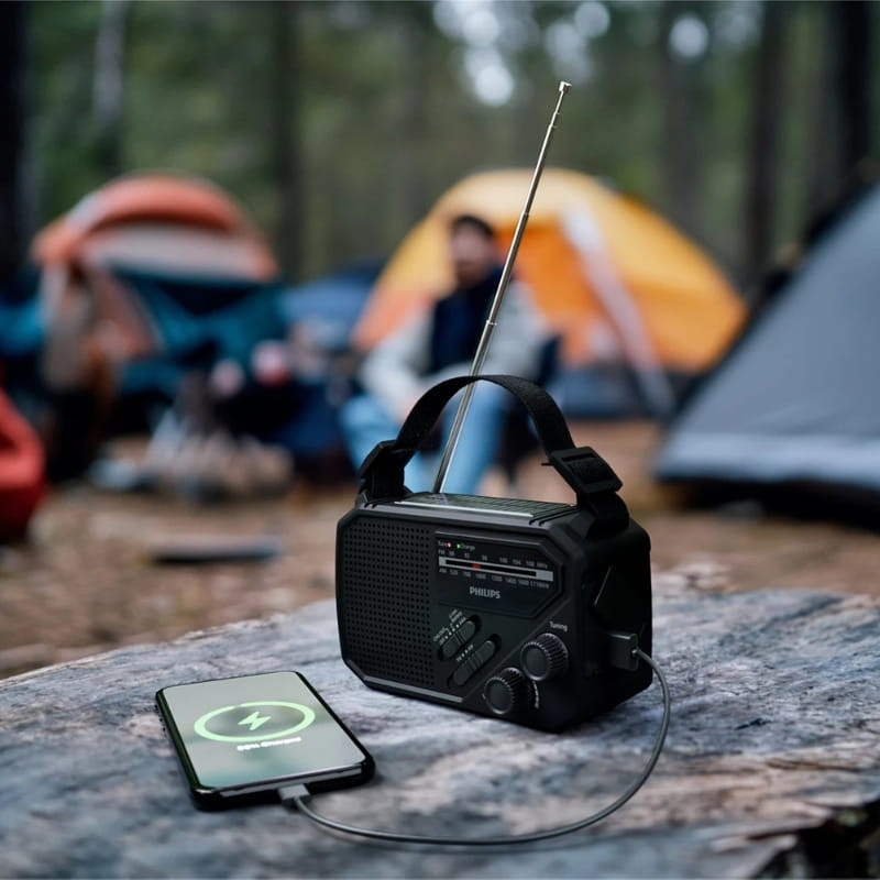 Philips TAR1609/00 radio portátil analógica negra con linterna, antena telescópica, dial y botones frontales, correa superior y puerto USB que carga el