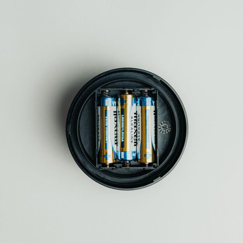 Compartiment circulaire noir avec trois piles AAA alignées, intérieur de la Balise de détresse Thulos TH-V16-2 Homologuée Géolocalisable Étui