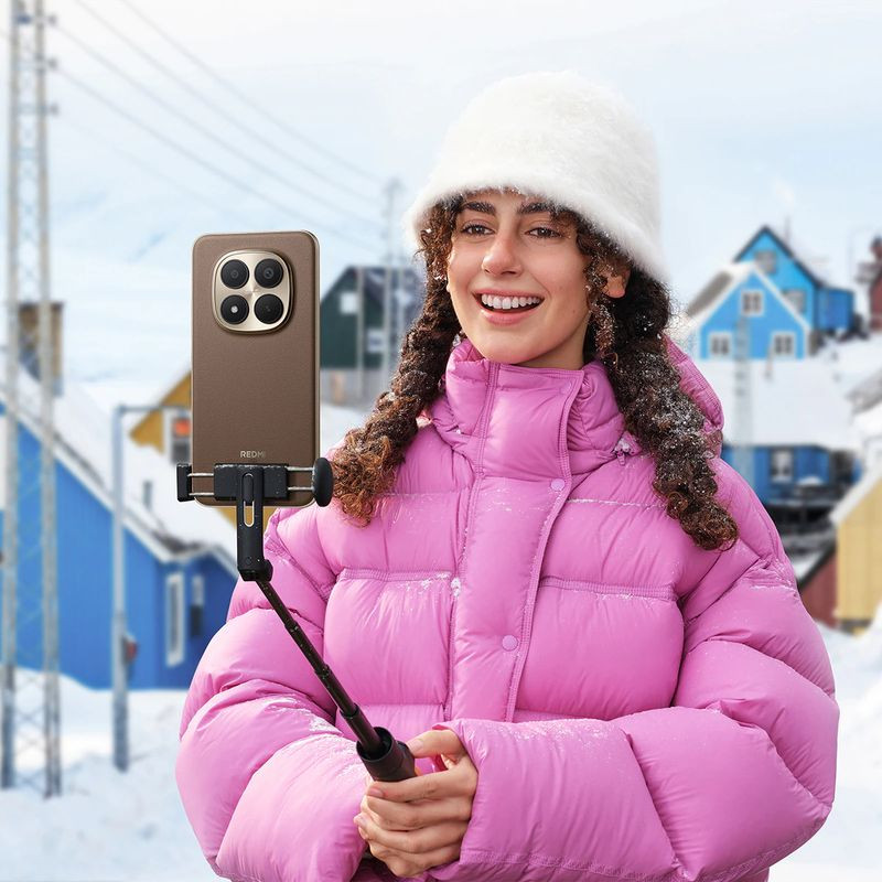 Xiaomi Redmi Note 15 Pro+ 8GB/256GB Preto com capa marrom, câmera traseira quádrupla grande, em suporte de selfie ao ar livre na neve