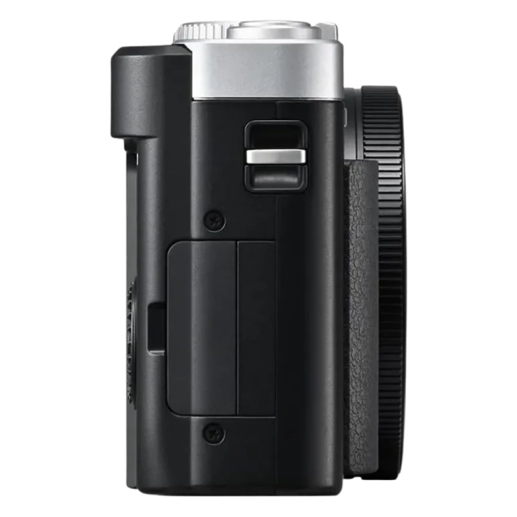 Vue latérale du Panasonic Lumix TZ99 Argent avec boîtier compact noir et argent, poignée texturée, commandes latérales accessibles et molette d'objectif proéminente