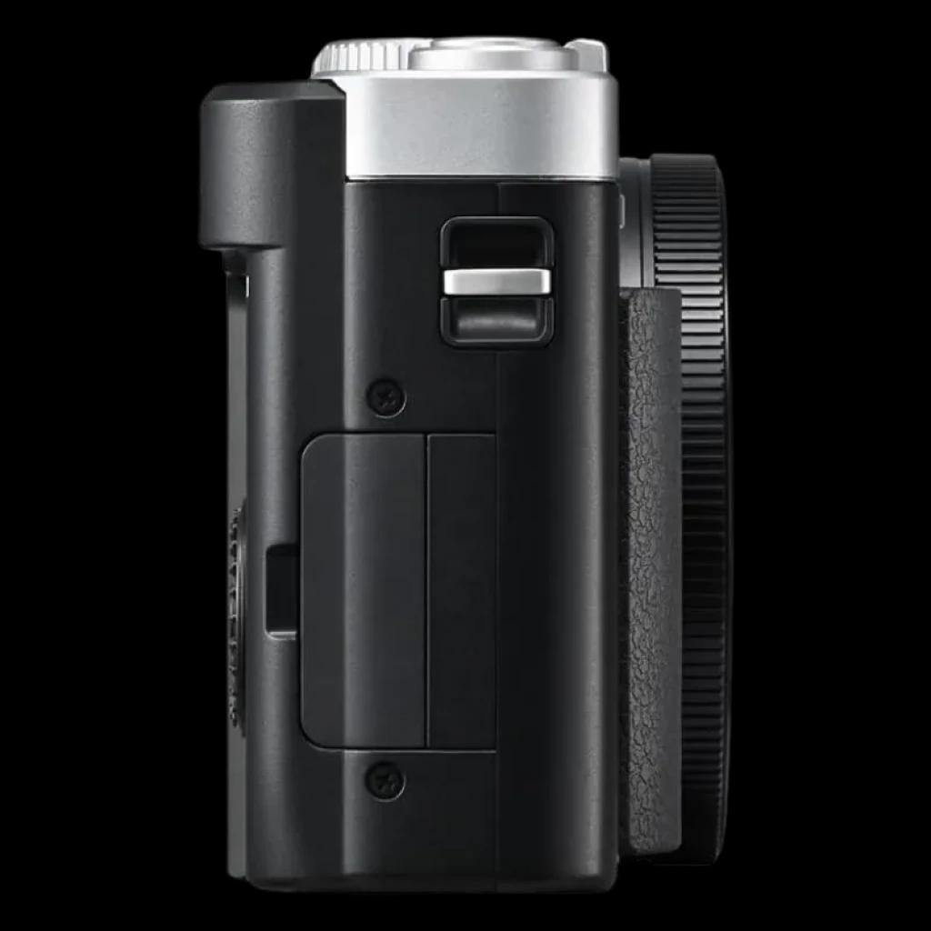 Vue latérale du Panasonic Lumix TZ99 Argent avec boîtier compact noir et argent, poignée texturée, commandes latérales accessibles et molette d'objectif proéminente