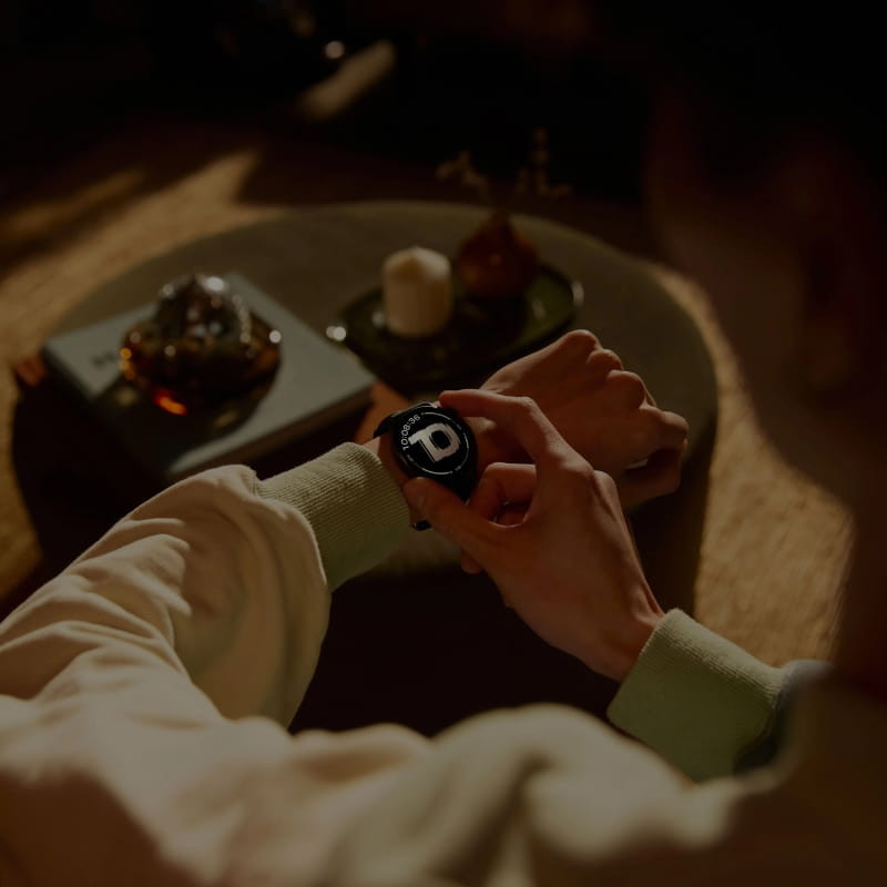 OnePlus Watch Lite Plata con pantalla circular negra, bisel metálico plateado y correa de silicona; interfaz deportiva visible y diseño elegante para uso