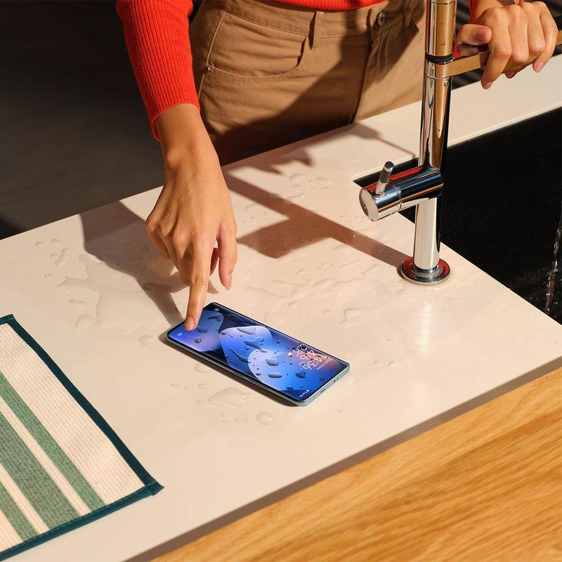 Xiaomi Redmi Note 15 5G 8GB/256GB púrpura sobre encimera mojada, pantalla encendida y resistente al agua, diseño moderno con bordes delgados y cámara