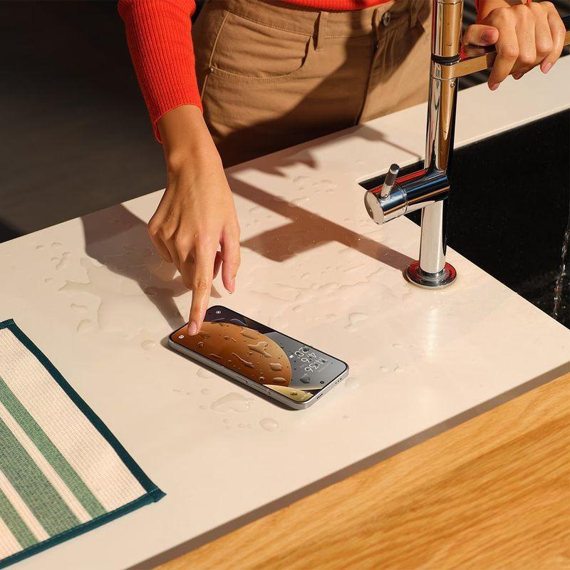 Xiaomi Redmi Note 15 Pro 5G 8Go/256Go Titane posé sur un plan de travail mouillé, écran allumé avec gouttes d’eau, design fin et élégant près d’un