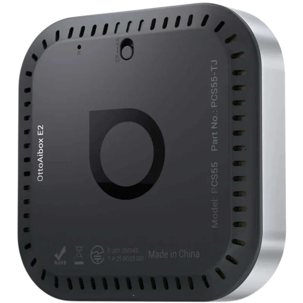 Ottocast OttoAibox E2 en negro mate, caja compacta con bordes ventilados, logotipo circular central, puerto frontal y certificaciones grabadas en la carcasa