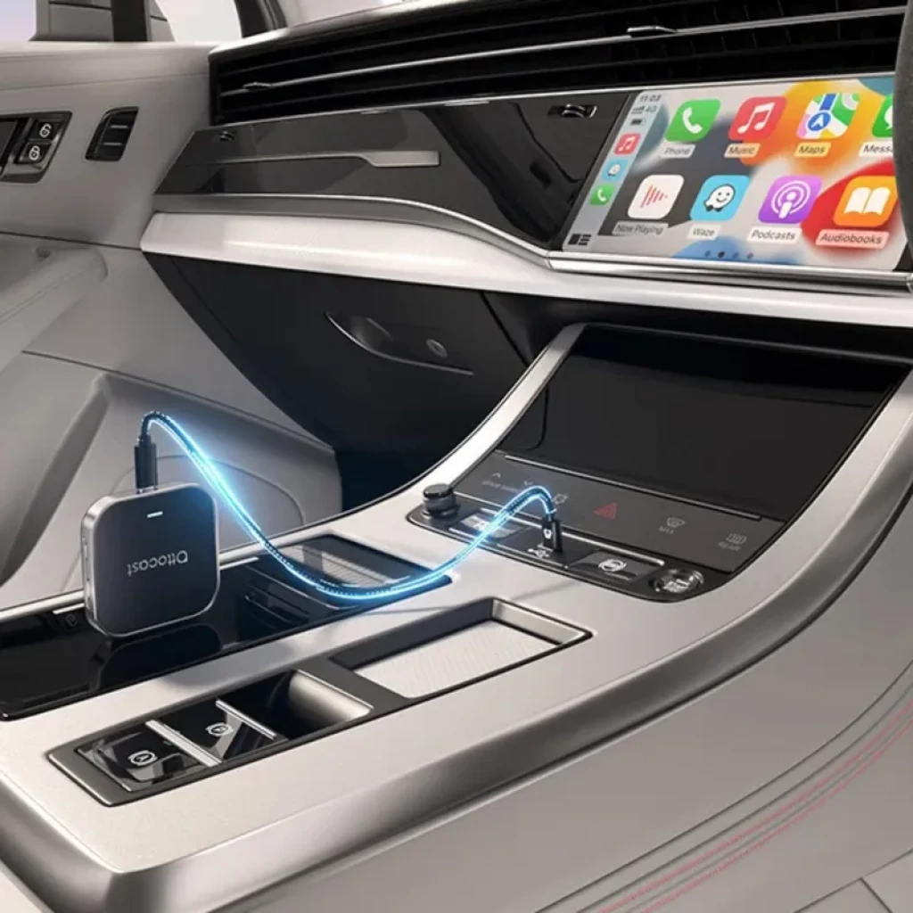 Ottocast OttoAibox E2 compacto en consola de coche, acabado gris con bordes redondeados, puerto USB‑C y cable conectado, luces LED azules indicando conexión