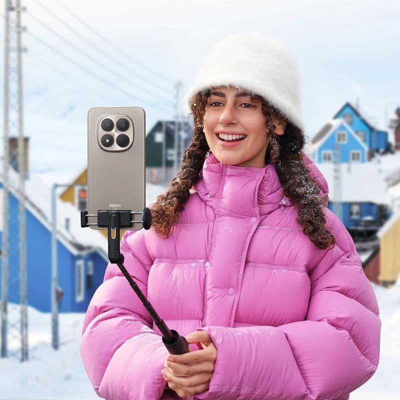 Xiaomi Redmi Note 15 Pro 4G Titâne com módulo de câmera quádrupla grande, acabamento metálico cinza, 12GB RAM e 256GB, preso a um bastão de selfie