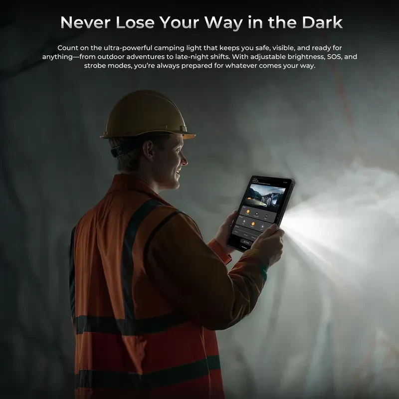 Trabalhador com capacete usa o tablet Oukitel RT10 5G preto, robusto, exibindo luz de acampamento potente com brilho ajustável em ambiente escuro
