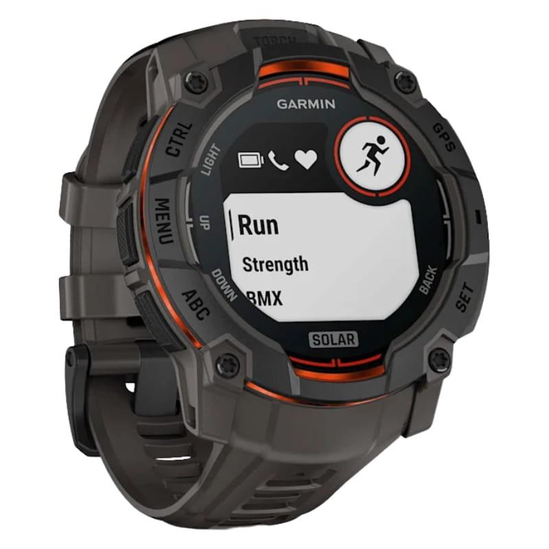 Garmin Instinct 3 50 mm Solar negro con correa de silicona carbón, bisel robusto, detalles naranjas, pantalla circular con iconos deportivos y botones