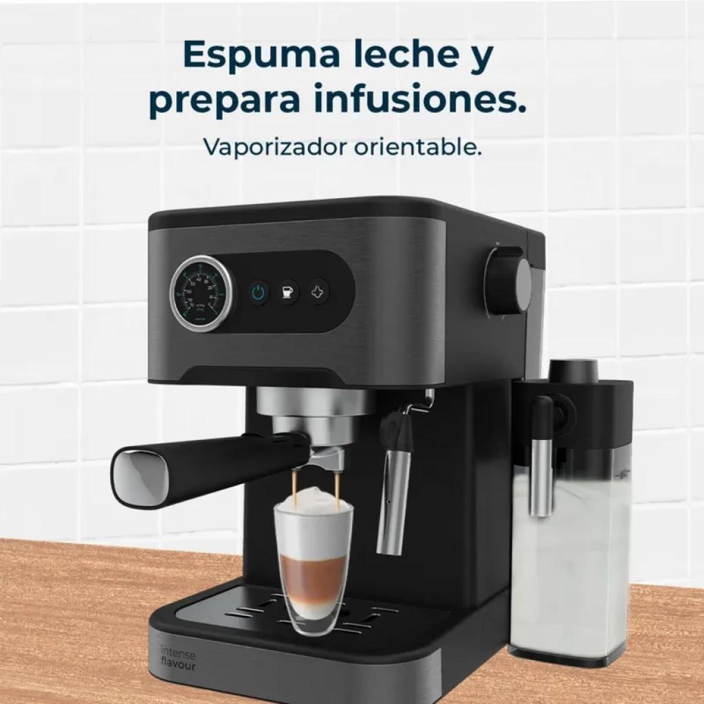 Cafetera express negra con manómetro frontal, portafiltro metálico, vaporizador orientable y depósito lateral de leche preparando un latte en vaso alto