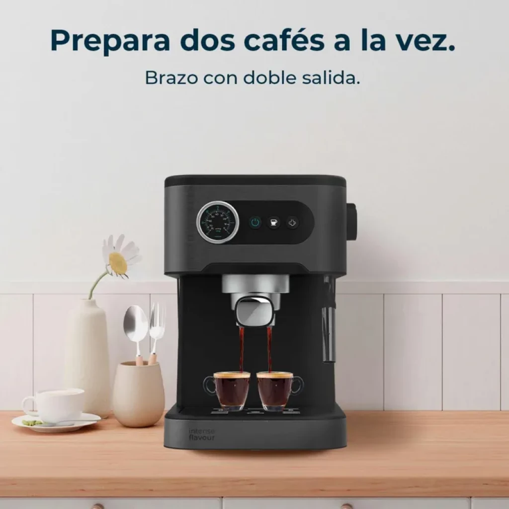 Cafetera express negra con manómetro circular, brazo con doble salida, dos tazas sirviéndose, depósito lateral transparente y botones frontales iluminados
