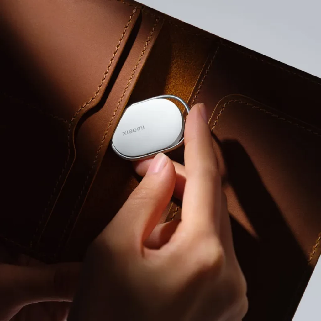 Localizador compacto ovalado en color blanco con borde metálico, diseño minimalista, cabe en billetera. Superficie lisa con logotipo Xiaomi discreto