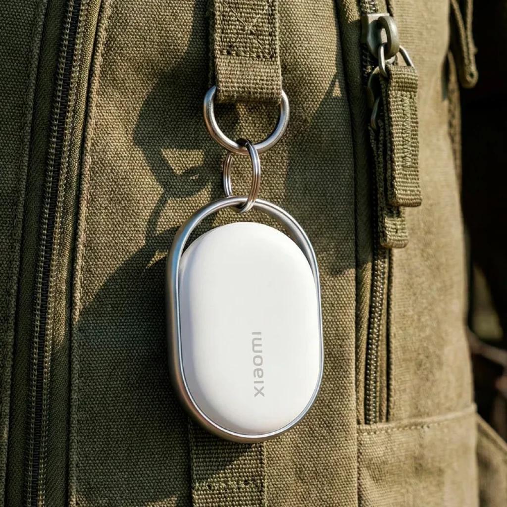 Xiaomi Tag NFC IP67 Bluetooth v5.4, localizador ovalado blanco con marco metálico, colgado en mochila