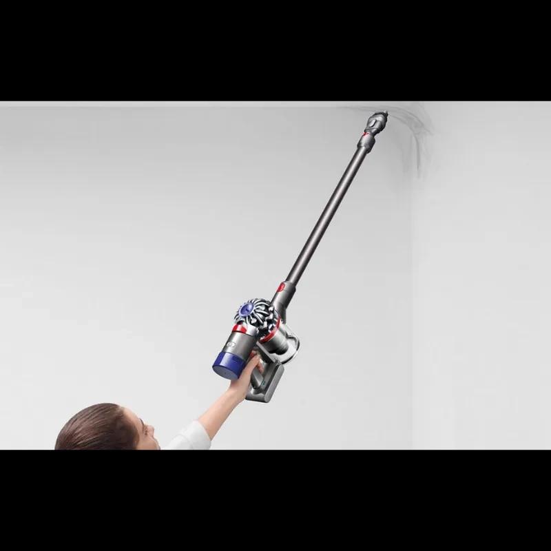 Dyson V8 Cyclone em uso: design leve e ergonômico, tubo longo alcança cantos altos, escova estreita para pó em tetos e bordas, acabamento cinza com detalhes