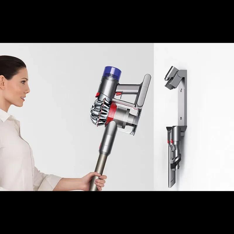 Dyson V8 Cyclone sem fios em base de parede, corpo prateado com detalhes roxos e vermelhos, acessórios acoplados e depósito transparente de 0,54 l