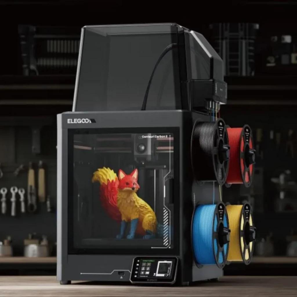 Elegoo Centauri Carbon 2 Combo FDM con cabina cerrada, pantalla táctil y cuatro portabobinas laterales; imprime figura multicolor visible en el interior