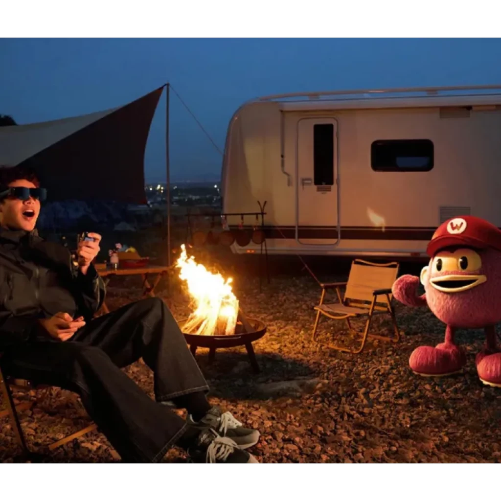 Homme portant AR RayNeo Air 3S Pro eyepiece près dun feu de camp, affichage AR lumineux 1200 nits 120Hz, visuel net de personnage virtuel en plein air