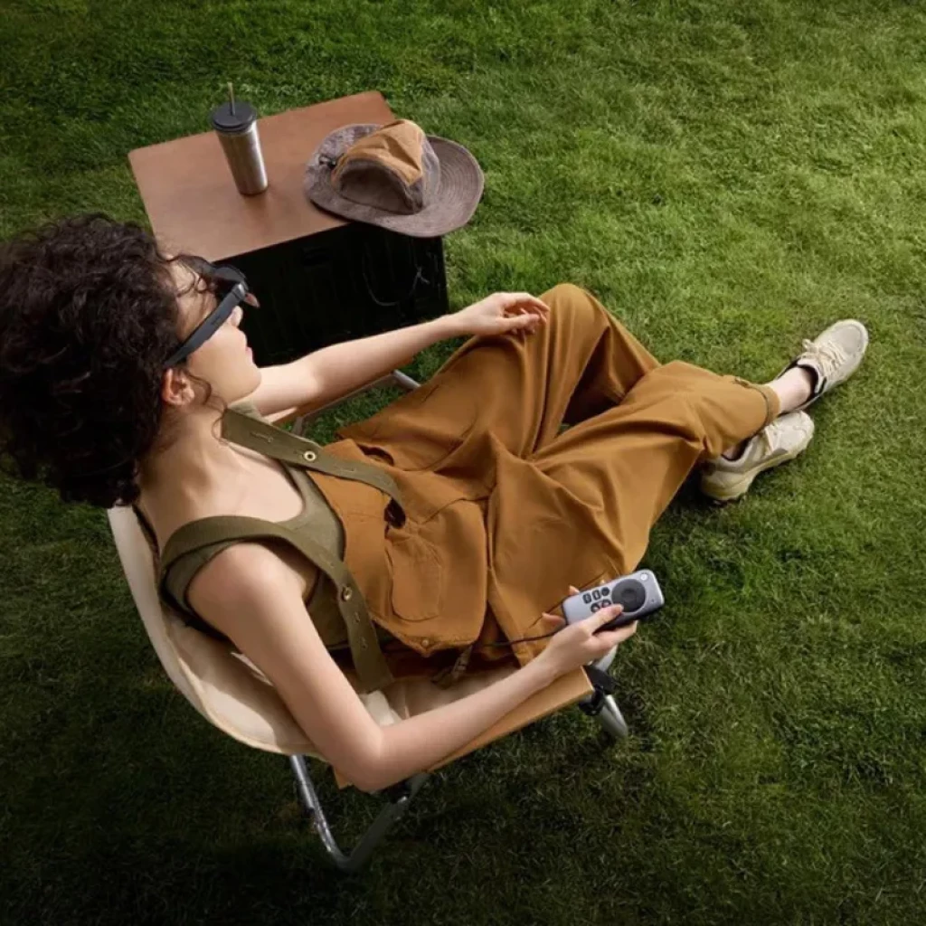 RayNeo Pocket TV - Télécommande tenue en main, design compact gris avec touches noires, écran et joysticks, idéale pour contrôler un mini projecteur